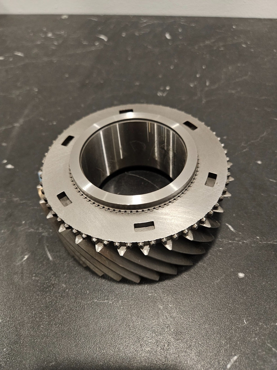 ZF S6-750 2nd gear mainshaft 37T displayed on a black surface, showcasing its detailed design and features.