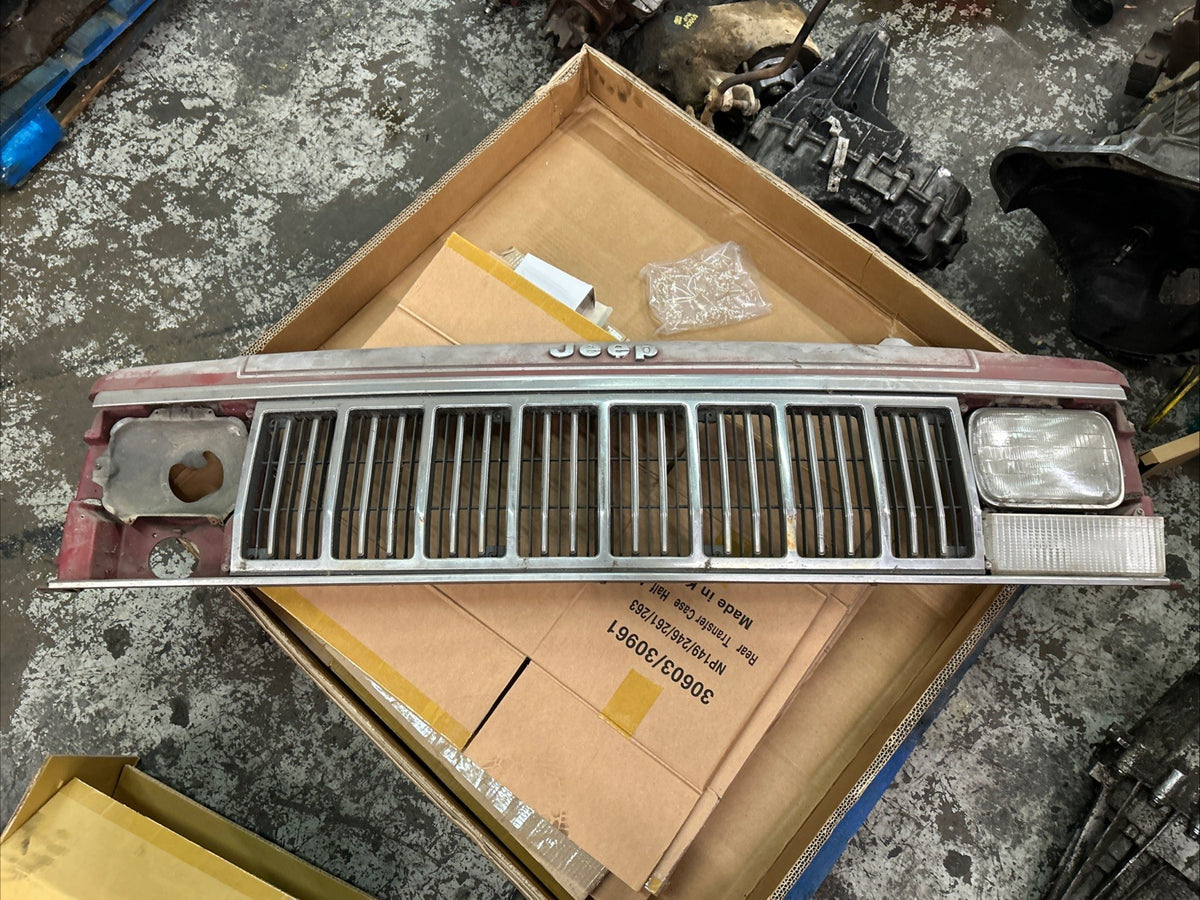 Jeep Comanche grill featuring distinct grill bars and headlight area, presented on a box background.