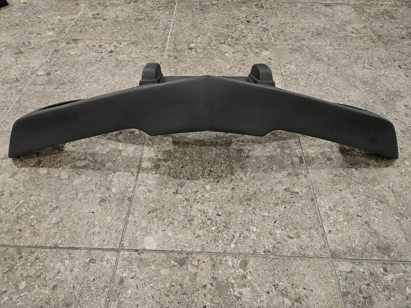 1975-1979 C3 Corvette fiberglass bumper displayed on a tiled surface, brand new and never installed.