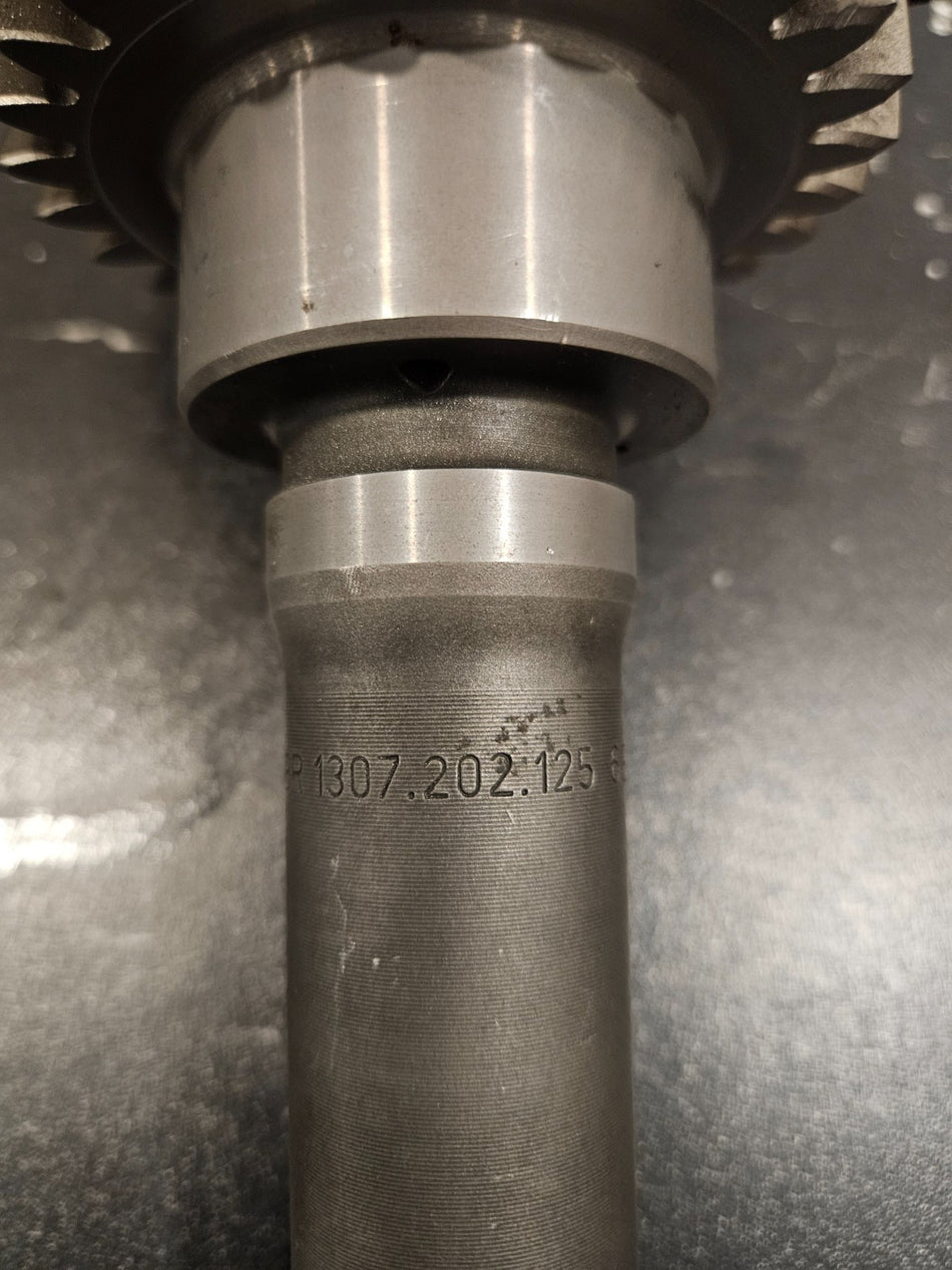 ZF S5-42 input shaft for Ford trucks showing detailed close-up of part number 1307-202-125 etched on the shaft.